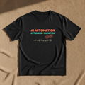 AI Automation = Extended Vacation tee in black, printed in orange and teal with an OUT OF OFFICE stamp, laid flat on a tan background