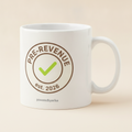 Pre-Revenue mug in white, printed with a round PRE-REVENUE est. 2026 badge with a green check mark
