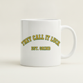 Est. Grind Varsity mug in white, printed with THEY CALL IT LUCK EST. GRIND in green and gold varsity lettering