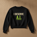 I Deserve AI fitted sweater in black, printed with I DESERVE in cream and A.I. in green, laid flat on a tan background